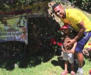 Antonio Valencia posa junto a un niño en la tumba de su amigo ‘Chucho’. Foto:  Facebook de Antonio Valencia