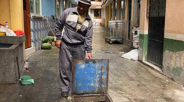 José Quimbita levanta la tapa del pozo de agua del que tomaban el líquido cuando el barrio se creó. Foto: Ana Guerrero / ÚN