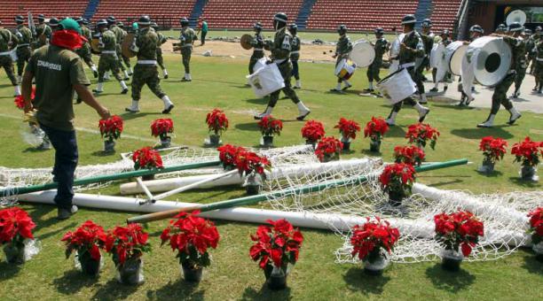 Un hombre decora los postes de un arco de fútbol, mientras miembros de la banda marcial del ejército colombiana ensayan hoy, miércoles 30 de noviembre de 2016, durante los preparativos del homenaje al equipo de fútbol Chapecoense que tendrá lugar en la no