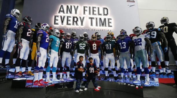 Niños posan frente a uniformes de varios equipos en la zona de aficionados hoy, miércoles 1 de febrero de 2017, antes del Super Bowl. Foto: EFE