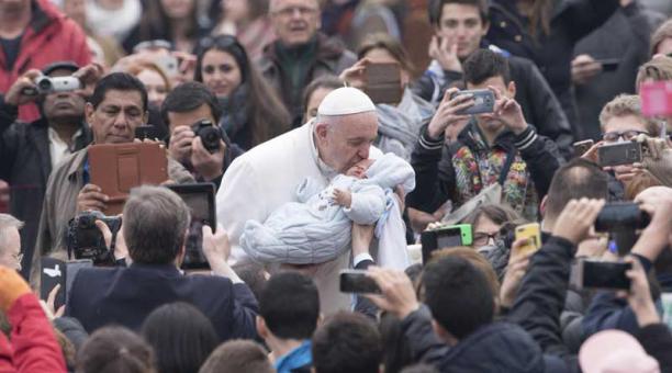 El papa Francisco besa a un bebé a su llegada a la audiencia general de los miércoles en la plaza de San Pedro en el Vaticano el 22 de febrero de 2017. Foto: EFE