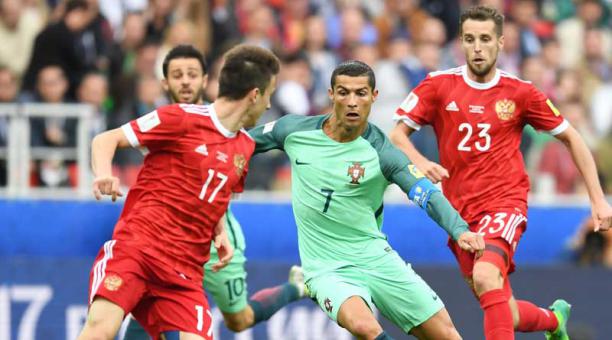 El astro Cristiano Ronaldo gambetea a dos zagueros rusos en el partido. Foto: EFE