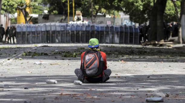 Un manifestante permanece sentado en frente de miembros de la Guardia Nacional Bolivariana (GNB) durante una de las protestas en el marco de la huelga general convocada por la oposición hoy, miércoles 26 de julio de 2017, en Caracas (Venezuela). Foto: EFE