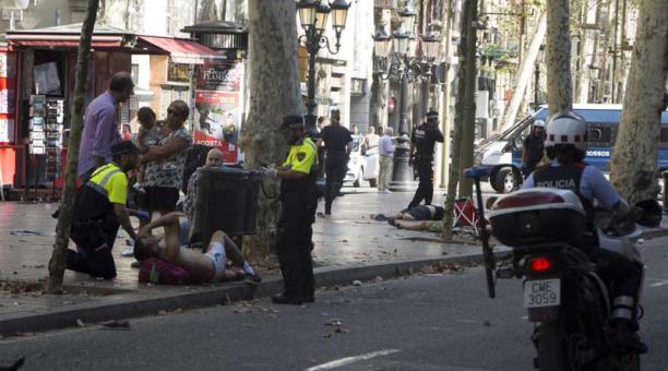 Efectivos policiales atienden a una de las víctimas de un atropello masivo en  las Ramblas de Barcelona. Foto: EFE