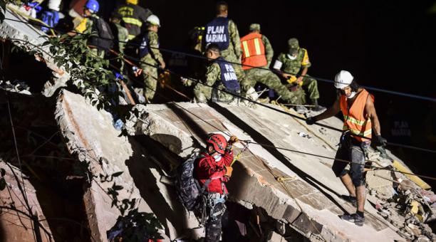 Los rescatistas, bomberos, policías, soldados y voluntarios retiran escombros de un edificio aplanado en busca de sobrevivientes. Foto: AFP