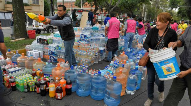 Los voluntarios distribuyen agua y otras bebidas donadas en un punto de distribución  en la Ciudad de México el 20 de septiembre de 2017. Foto: AFP