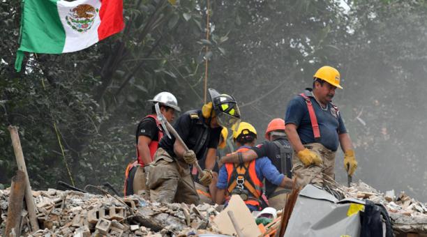Los bomberos mexicanos eliminan los escombros de un edificio multifamiliar que se derrumbó durante el terremoto de 7.1 grados al lado de la carretera Tlalpan en la Ciudad de México el 26 de septiembre de 2017. Foto: AFP
