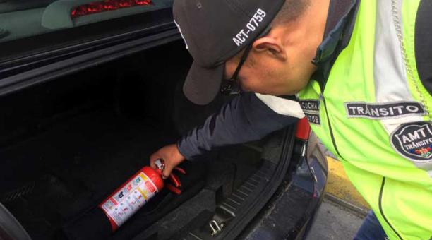 Un agente de tránsito revisa el extintor de un conductor en la Shyris. Foto: Paúl Rivas / ÚN