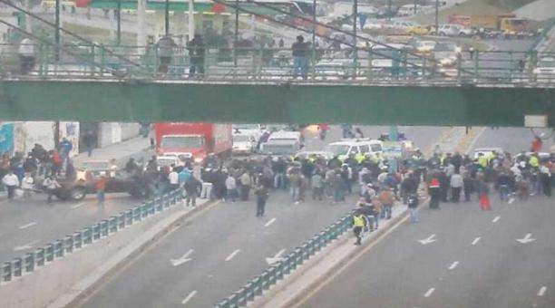 Un grupo de personas se desplegó a lo ancho de la avenida Panamericana Norte, como medida de protesta, y bloqueó el paso de los vehículos a la altura del sector de Carapungo. Foto: Twitter AMT