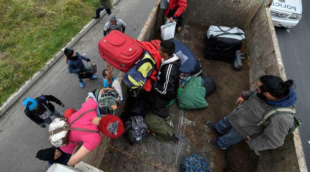 Migrantes venezolanos en el Carchi suben en una volqueta para continuar el viaje hacia Quito. Foto: AFP
