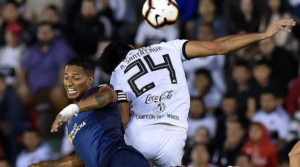 Antonio Valencia (izq.) pelea por el balón ante Roque Santa Cruz, en el partido disputado en el estadio Defensores del Chaco. Foto: AFP