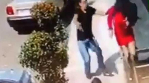 La captura de video muestra cómo dos transeúntes son atacados y amenazados para quitarles sus pertenencias.