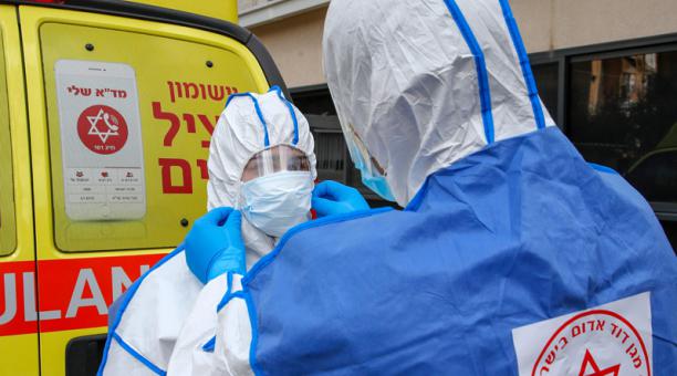 Los paramédicos israelíes de Maguen David Adom (Organización Médica Nacional Prehospitalaria de Emergencia de Israel) en el centro nacional de operaciones de coronavirus, se preparan con ropa protectora durante un ejercicio de entrenamiento de respuesta d