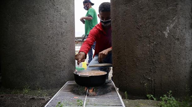 Un grupo de ciudadanos venezolanos hacen una parada para alimentarse en la Panamericana Sur, sector de El Rosal en el cantón Mejía, mientras se trasladan a pie hacia la frontera con Colombia para tratar de llegar a su país. Foto: Diego Pallero / ÚN