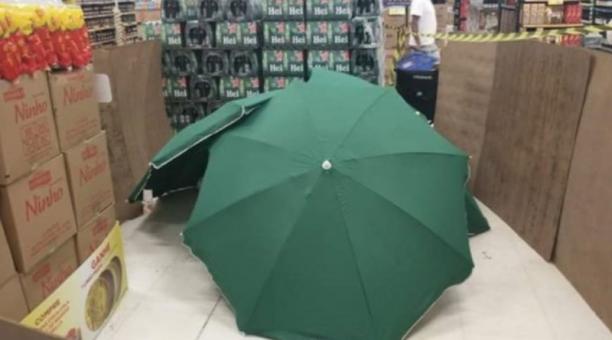 Esta es la imagen que circula en redes sociales sobre el momento que se cubrió con paraguas el cádaver.