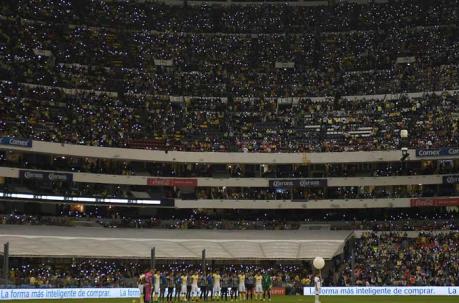 Los aficionados brillan durante el minuto de silencio en memoria de los futbolistas del equipo Chapecoense de Brasil en el estadio Azteca en Ciudad de México, México, 4 de diciembre de 2016. Foto: AFP