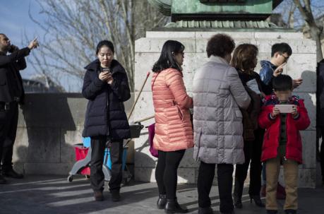 Turistas realizan fotografías con sus teléfonos móviles en los alrededores del museo Louvre en París. Foto: EFE