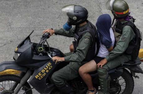 Miembros de la Guardia Nacional Bolivariana (GNB) detienen a un manifestante opositor luego de unos enfrentamientos en Caracas. Foto: EFE