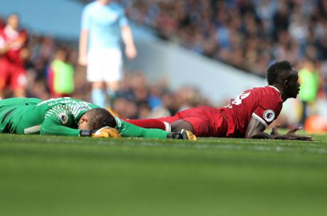 Ederson Santana de Moraes (izq.) recibe una fuerte falta de Sadio Mane durante el partido entre Manchester City y Liverpool. Foto: EFE