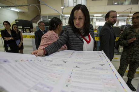Miembros del Consejo Nacional Electoral (CNE) revisan las papeletas para la consulta popular. Foto: EFE