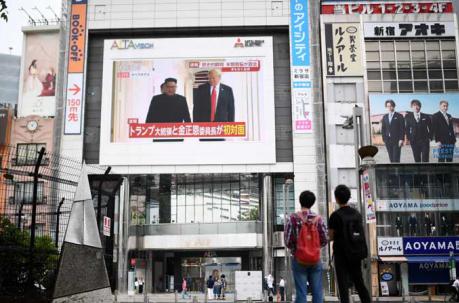 Los peatones miran una pantalla que muestra noticias del encuentro entre el líder norcoreano Kim Jong Un y el presidente estadounidense Donald Trump en Tokio el 12 de junio de 2018. Foto: AFP