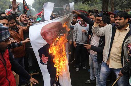 En Nueva Delhi, protestantes queman un cartel del presidente Donald Trump. Foto: EFE