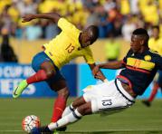 Enner Valencia (der.) defiede la pelota ante Yerry Mina de Colombia. Foto: AFP