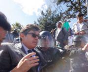 Desde el grupo de personas concentradas en la Fiscalía arrojaron agua sobre la cabeza de César Montúfar. Foto: Alfredo Lagla / ÚN