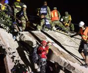 Los rescatistas, bomberos, policías, soldados y voluntarios retiran escombros de un edificio aplanado en busca de sobrevivientes. Foto: AFP