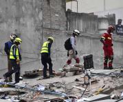 Los organismos de rescate durante la búsqueda de personas atrapadas entre los escombros. Foto: AFP